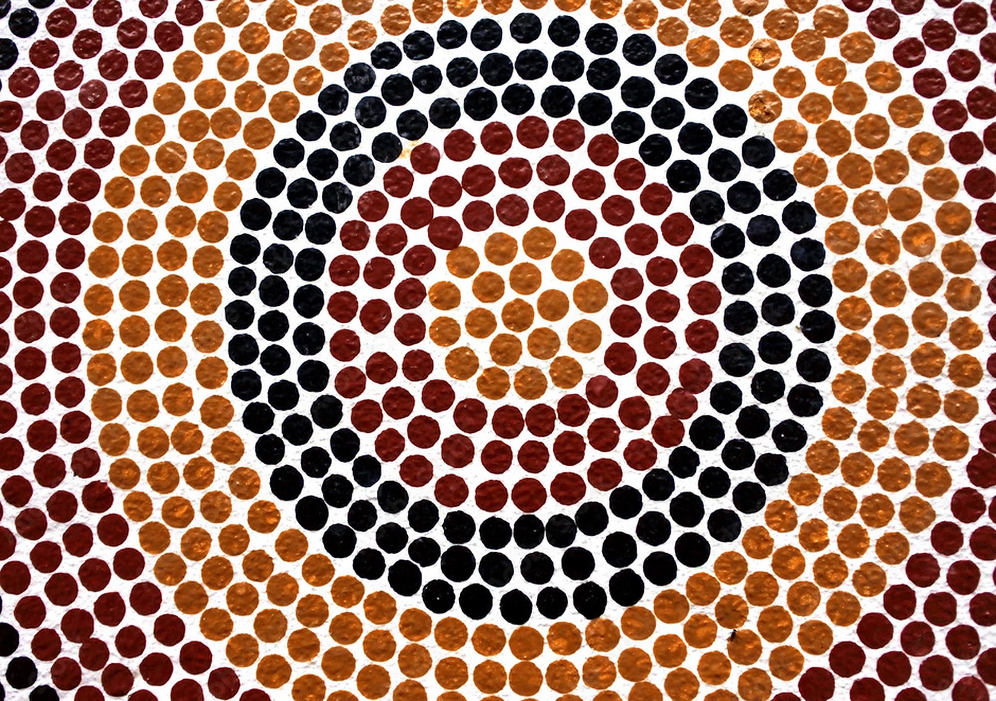 Dot painting artwork of concentric circles in ochre, rust and black